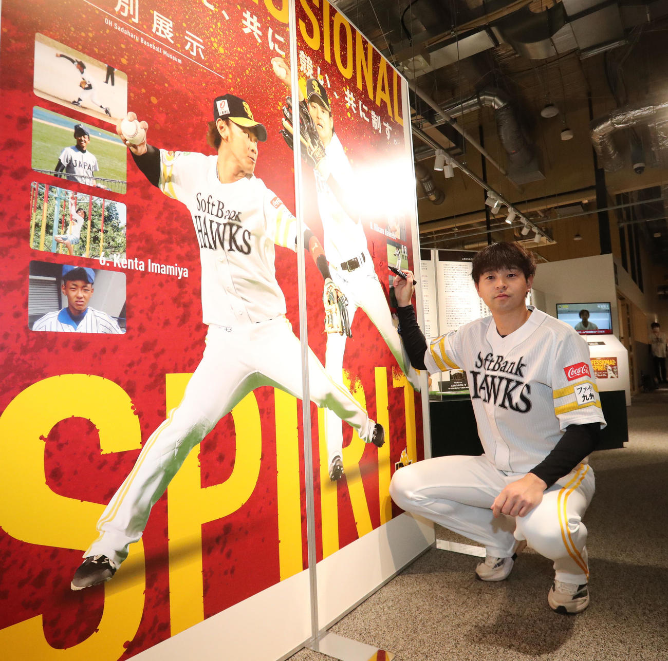 展示パネルにサインをする川瀬（撮影・梅根麻紀）