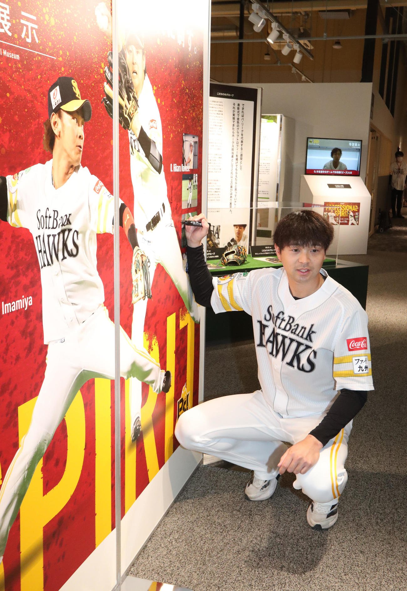 展示パネルにサインをする川瀬（撮影・梅根麻紀）