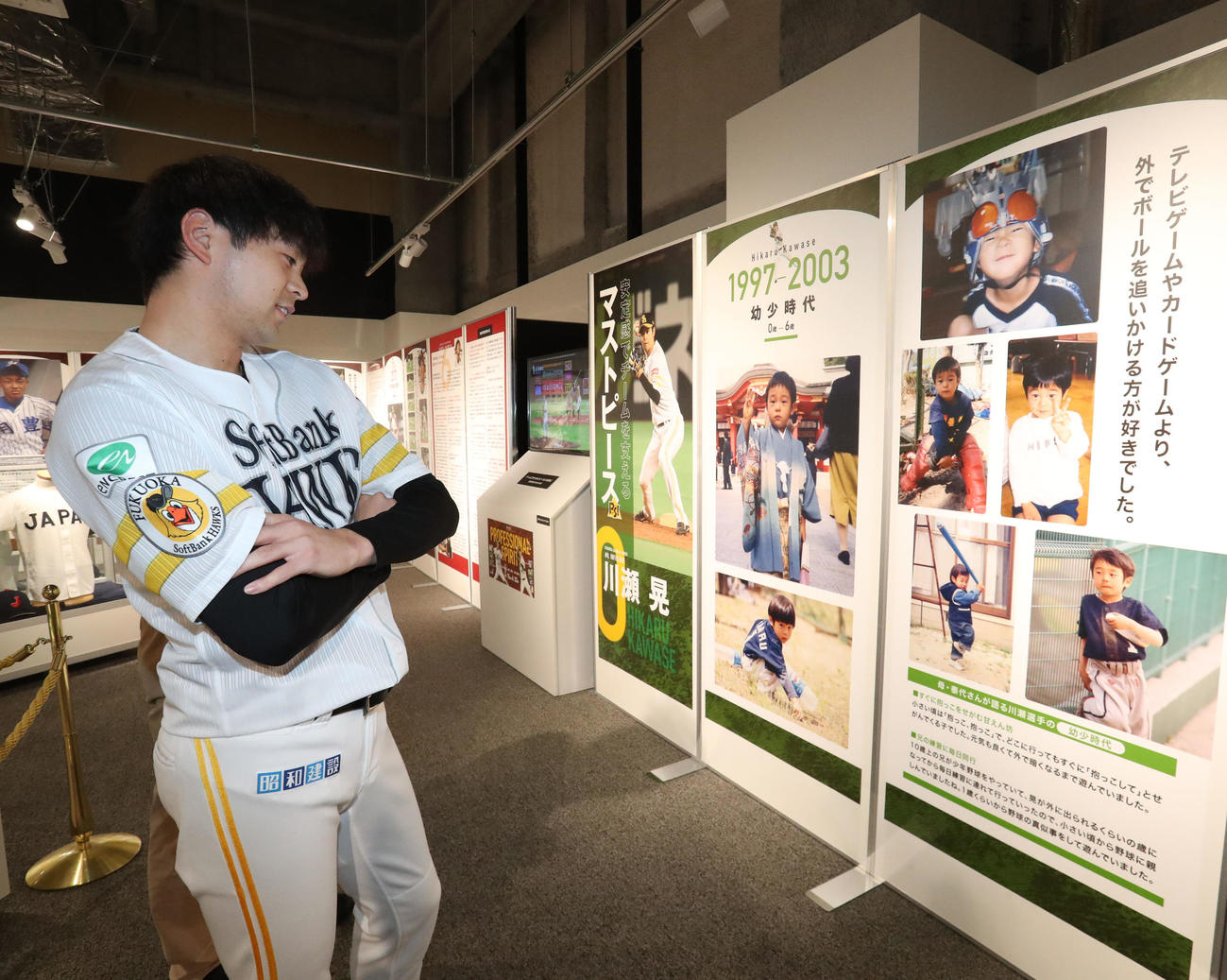 館内に展示された幼少期の写真を懐かしそうに内覧する川瀬（撮影・梅根麻紀）