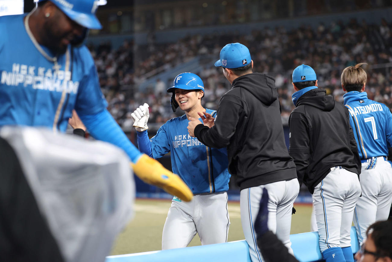 ロッテ対日本ハム　6回表1死満塁、吉田の3点適時三塁打で生還死、チームメートに迎えられる石井（撮影・河田真司）