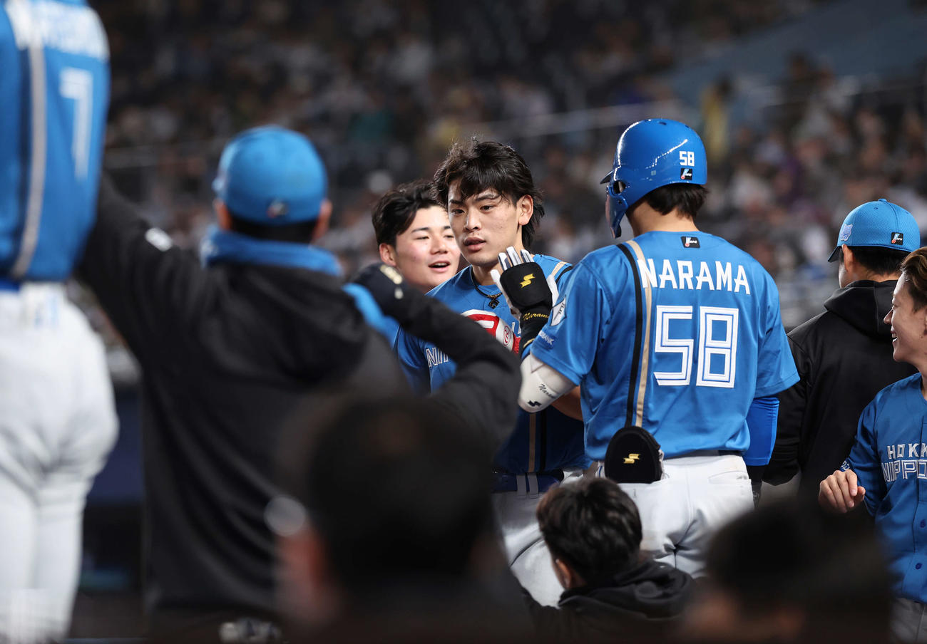 ロッテ対日本ハム　6回表1死満塁、石井一成の適時打で生還し、チームメートに迎えられる野村（撮影・河田真司）