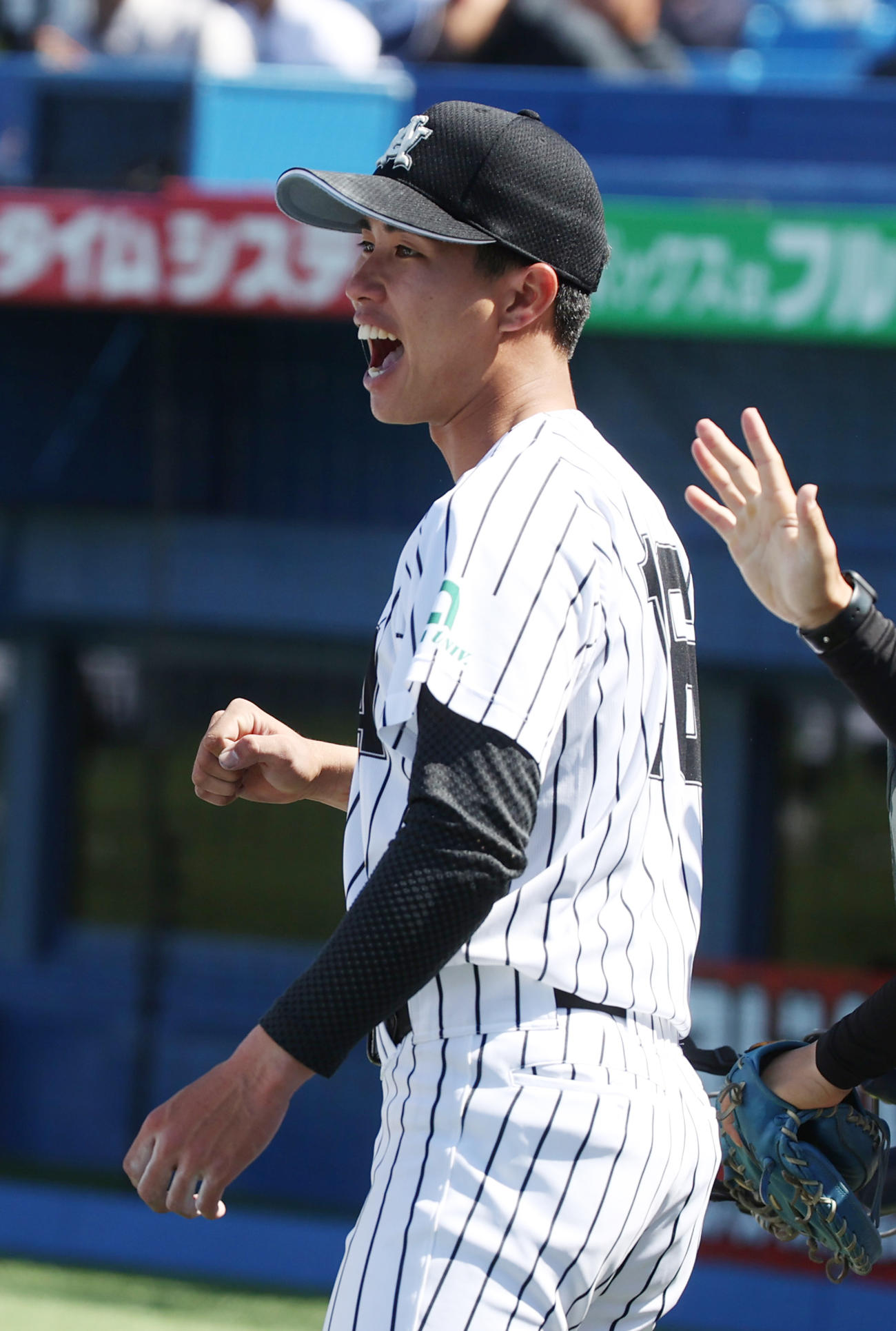 亜大対中大　亜大・山城は7回のピンチを抑えた井上を出迎えを受ける（撮影・柴田隆二）