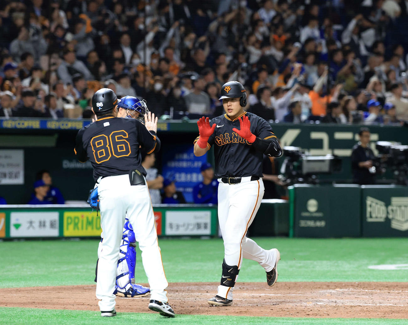 巨人対DeNA 5回裏巨人2死二塁、岡本は2点本塁打を放ちハイタッチで生還（撮影・浅見桂子）