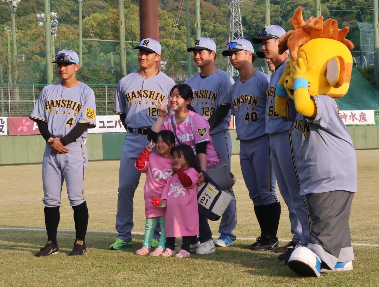 高知市在住の宮本さん親子と記念撮影を行う阪神の選手たち、左から熊谷、森木、松原、井坪、福島、山田（撮影・塚本光）