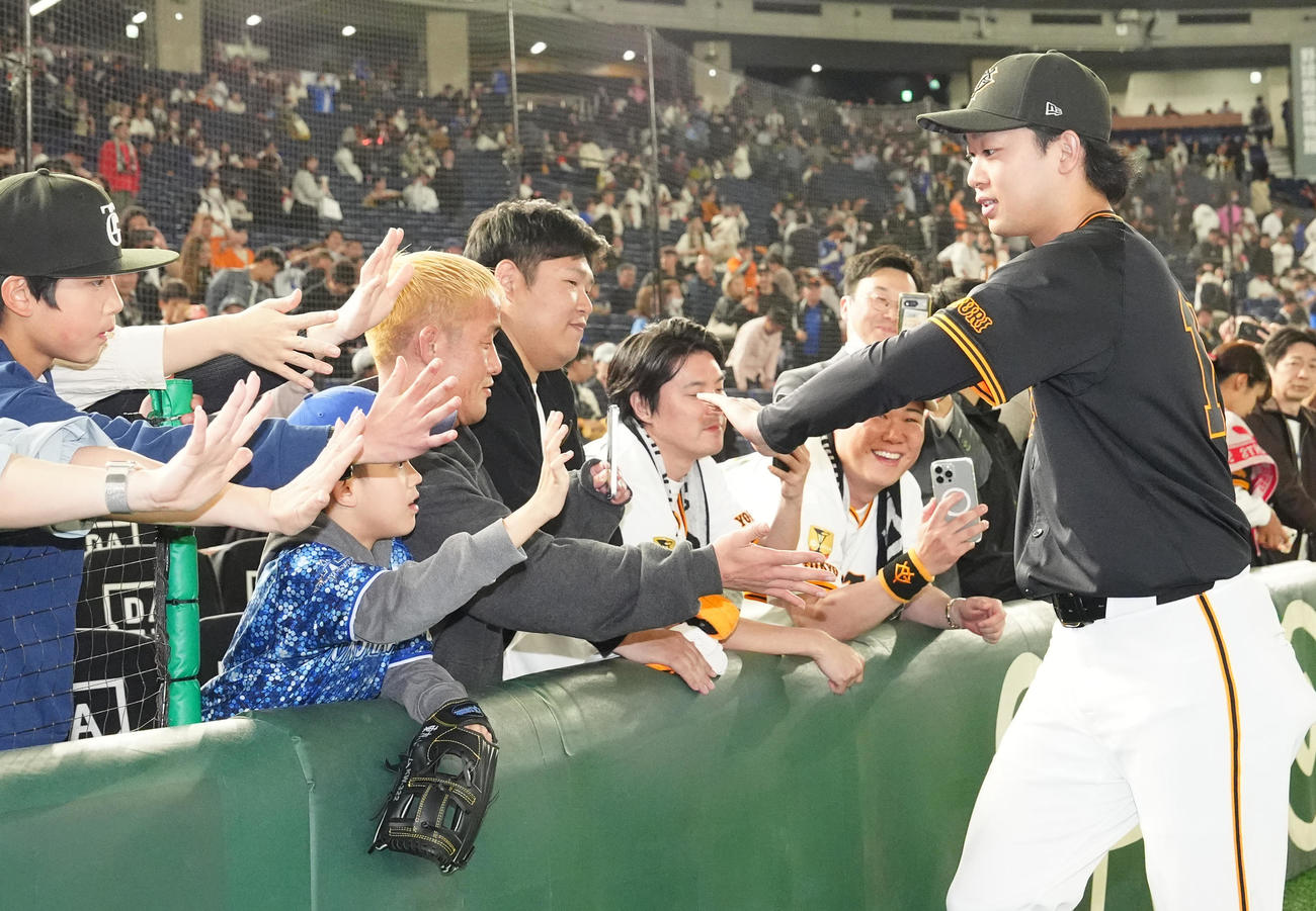 巨人対DeNA　試合後、ファンとタッチを交わす巨人山崎（右）（撮影・江口和貴）