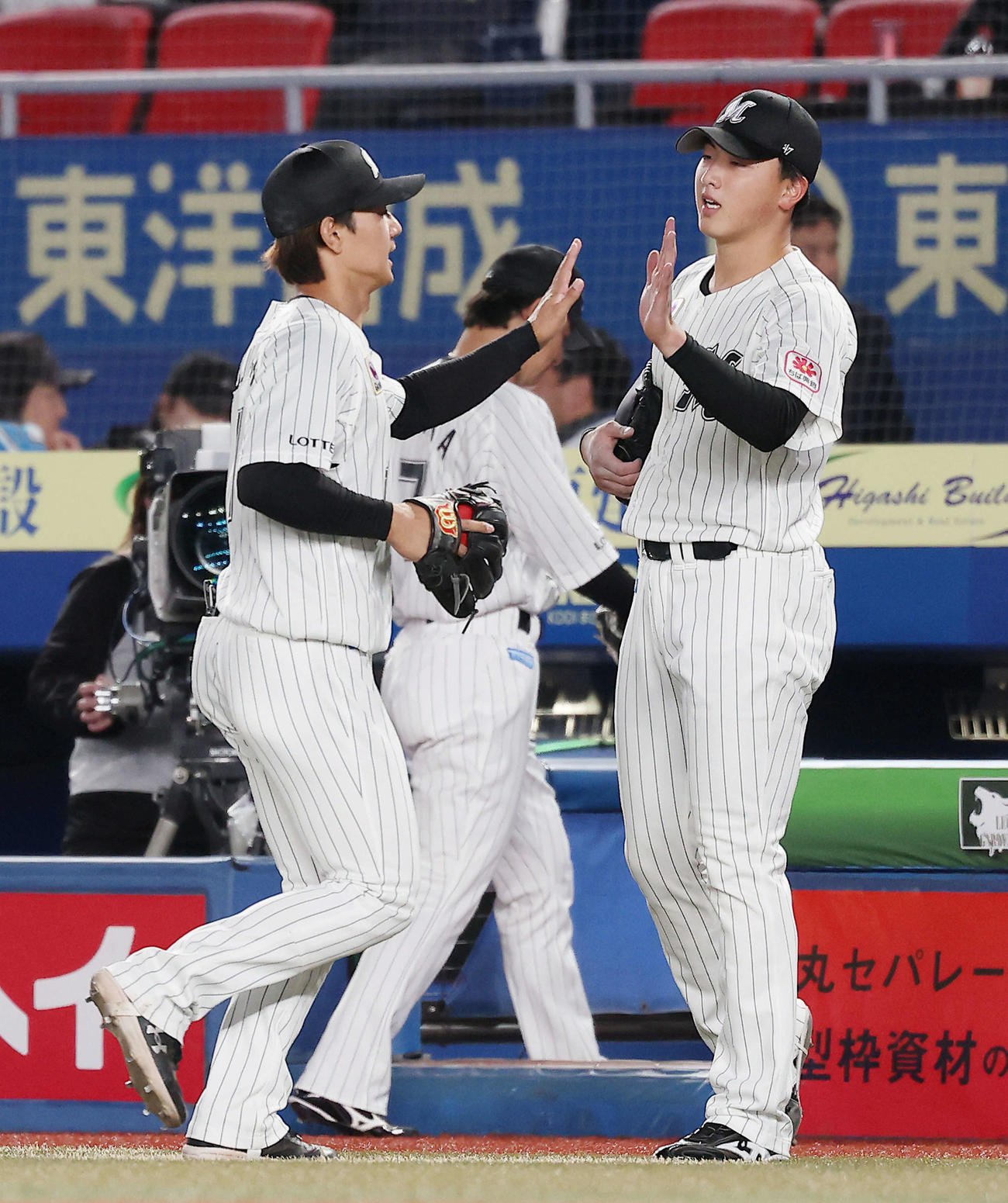 ロッテ対日本ハム　4回表を抑え、藤原（左）らナインを迎える田中晴（撮影・河田真司）
