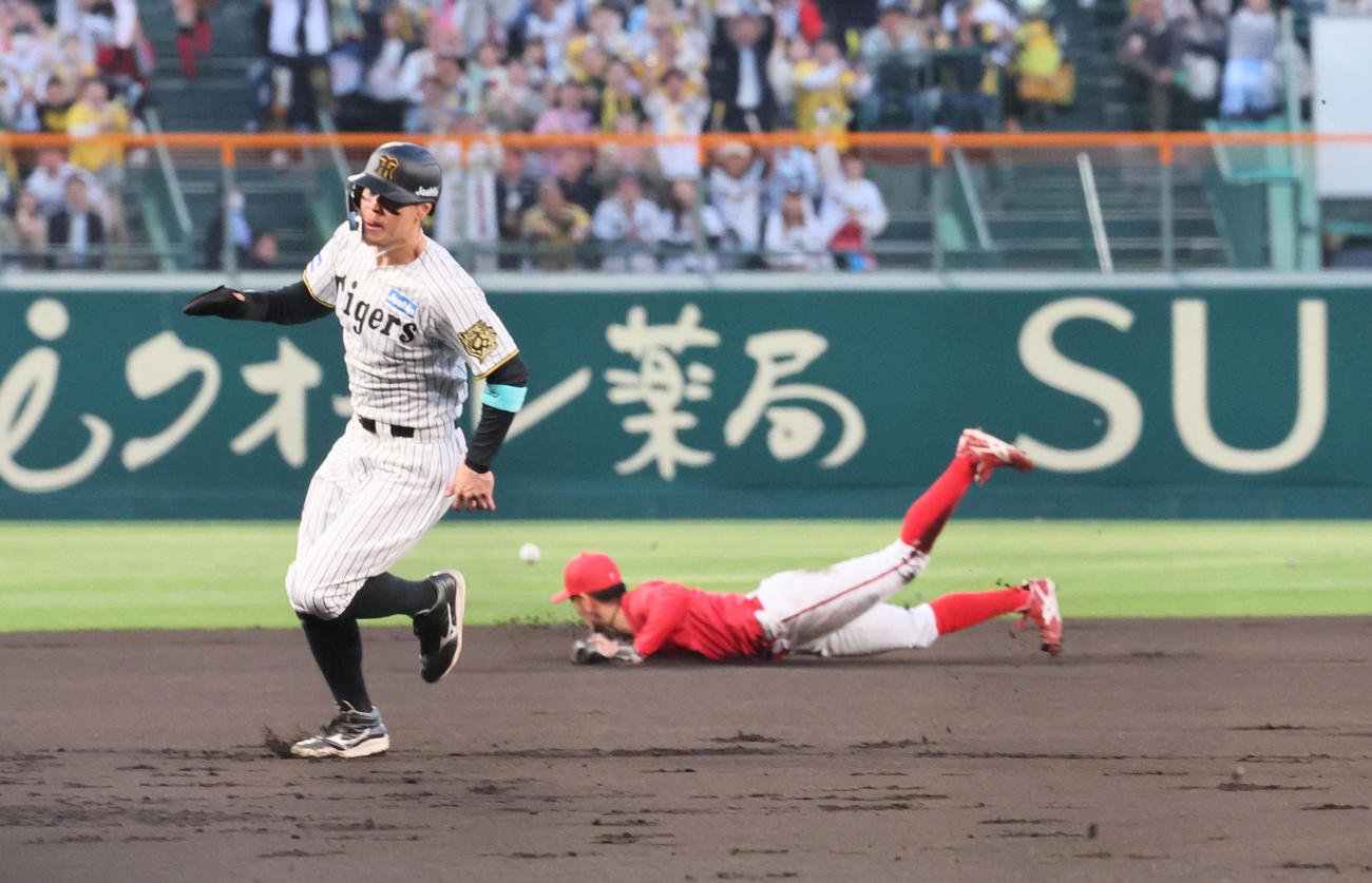 阪神対広島　1回裏阪神2死満塁、佐藤輝は前川の左翼への先制2点適時打で三塁に向かう（撮影・宮崎幸一）