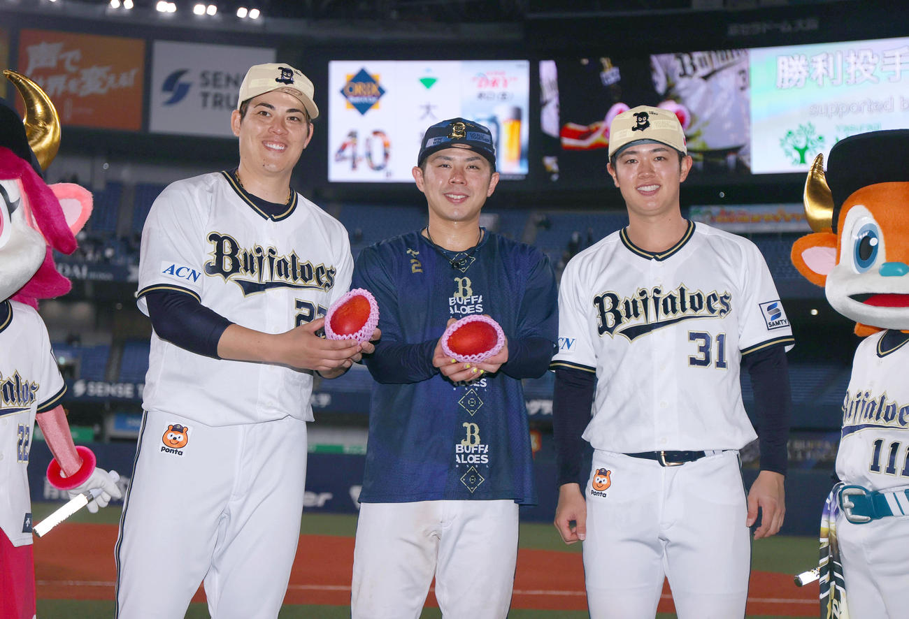 オリックス対日本ハム　「キャンプ地みやざきシリーズ」に勝利しマンゴーを手に写真に納まるヒーローの、左から九里、若月、太田（撮影・上山淳一）