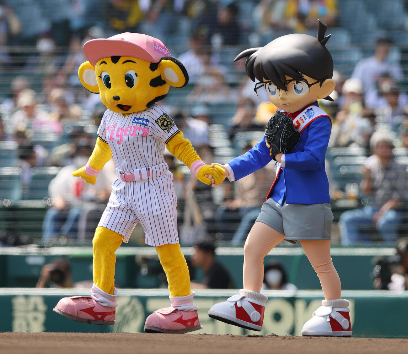阪神対広島　試合前、ファーストピッチセレモニーに臨む江戸川コナン（右）はラッキーの案内でマウンドへ向かう（撮影・上山淳一）