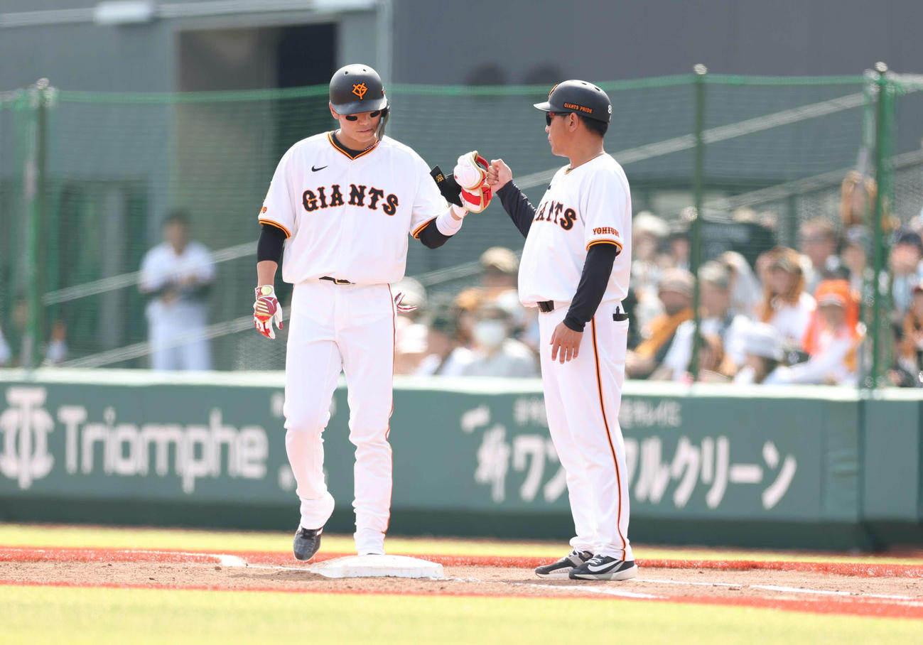 巨人対西武　4回裏巨人1死一、二塁、内野安打とし、脇谷一塁ベースコーチ（右）とタッチを交わす坂本（撮影・増田悦実）