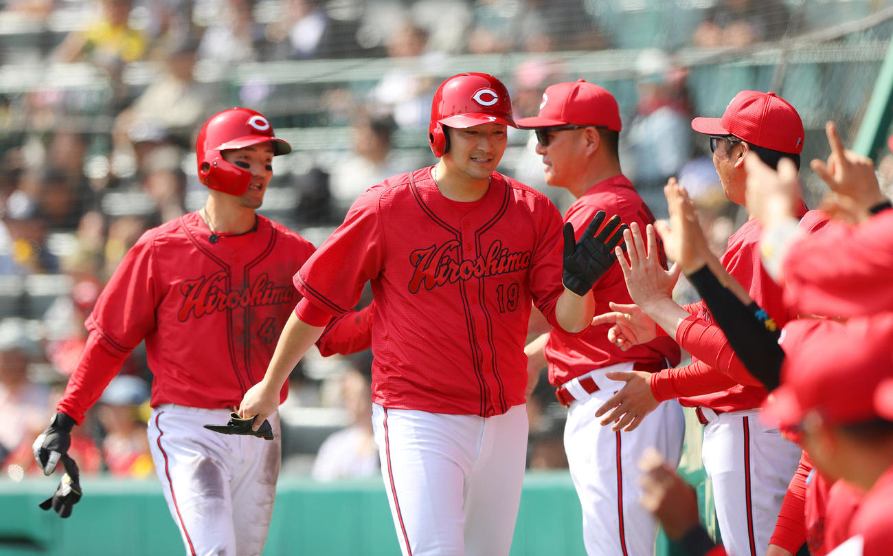 阪神対広島　2回表広島2死二、三塁、羽月の中前2点適時打で生還し仲間から出迎えられる三走床田（左から2人目）と二走矢野（左）（撮影・上山淳一）