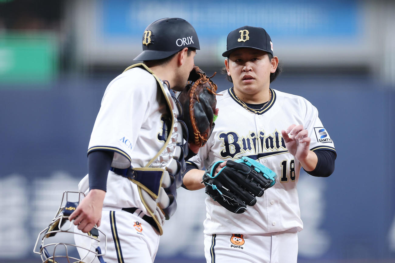 オリックス対日本ハム　1回表を投げ終え、オリックス福永（左）と言葉を交わしながらベンチへ戻る宮城（撮影・前田充）