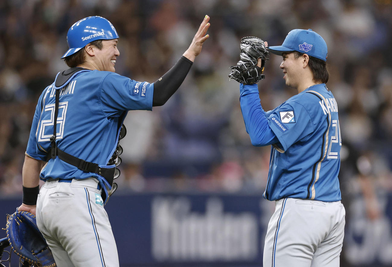 オリックスに完封勝利し、笑顔でタッチを交わす日本ハム金村と捕手伏見（共同）