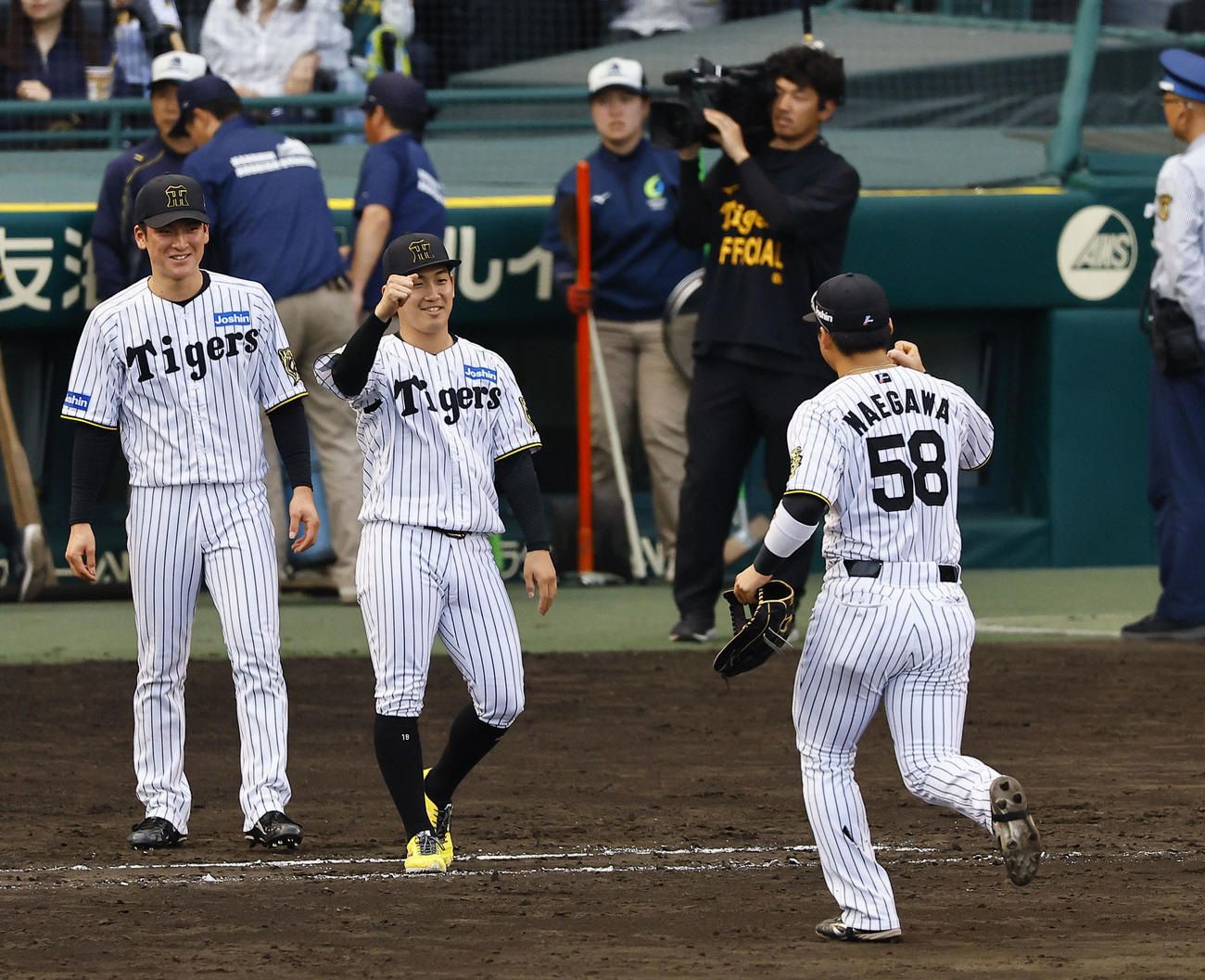 阪神対広島　プロ初勝利を飾り、ガッツポーズでナインを出迎える伊原（中央）（撮影・藤尾明華）