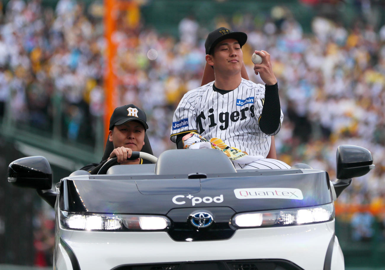 阪神対広島　初先発で初勝利を上げた阪神伊原はリリーフカーに乗りながらウイニングボールを見つめる（撮影・上山淳一）