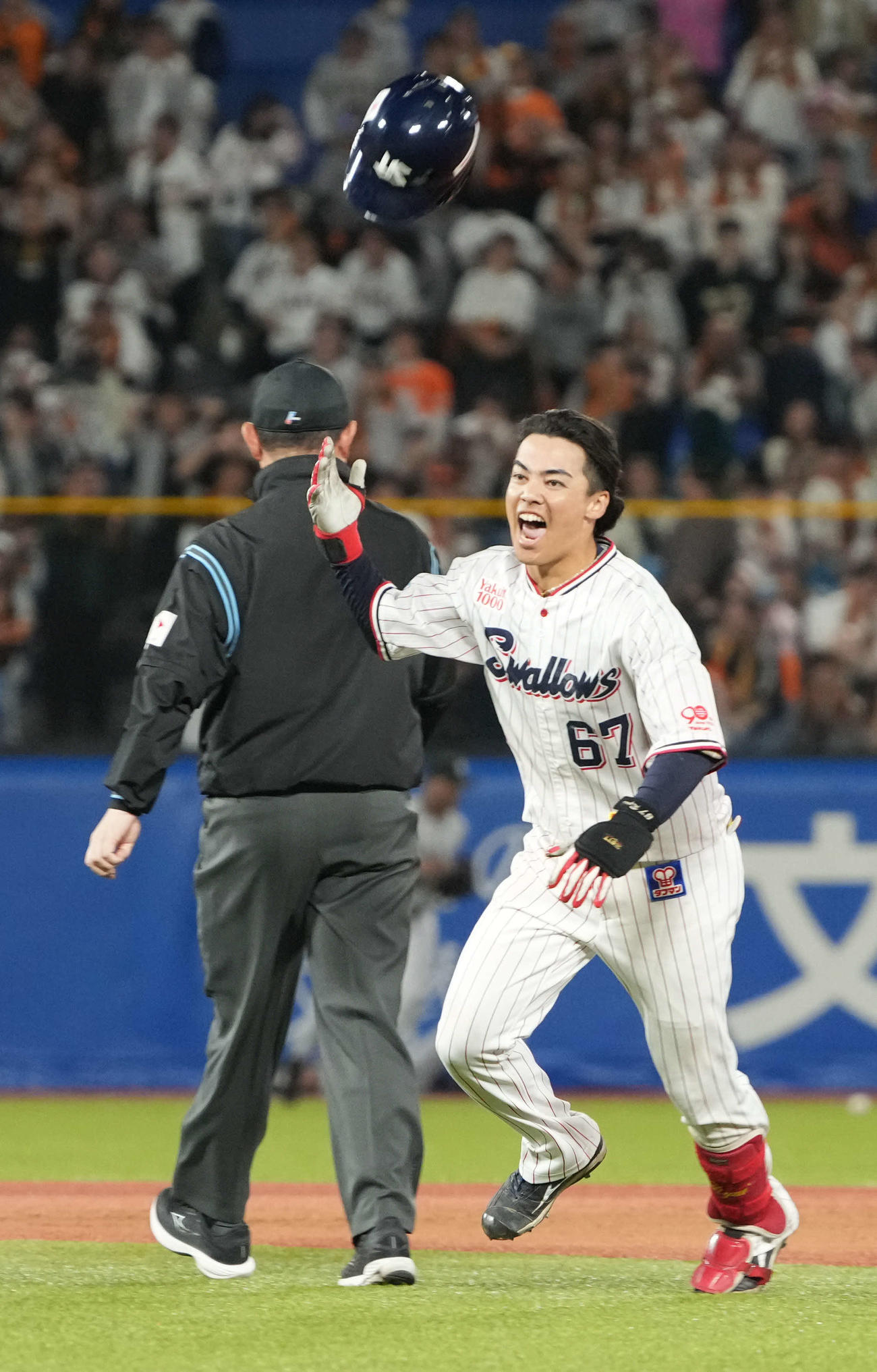 ヤクルト対巨人　延長10回裏ヤクルト2死二、三塁、伊藤（左）は左越えにサヨナラ打を放ちヘルメットを放り投げナインの元に向かう（撮影・小沢裕）