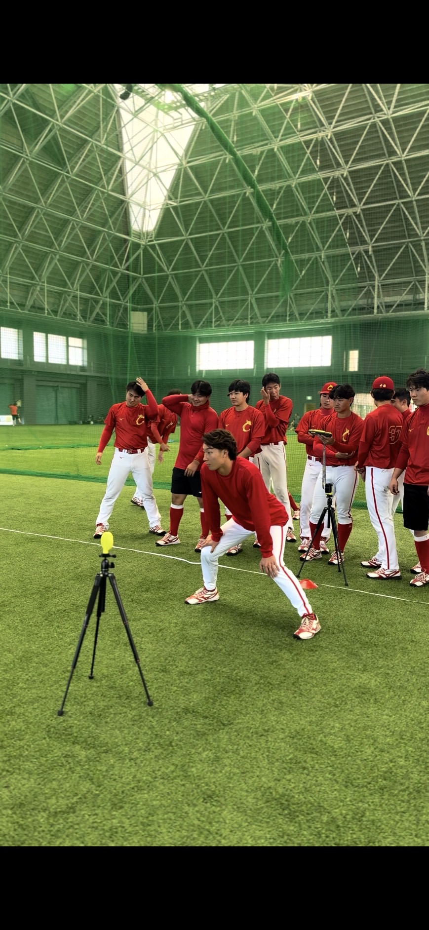 下向井総合コーチから光電管センサーを使用した走塁練習の指導を受ける北京タイガース・梁外野手（提供写真）