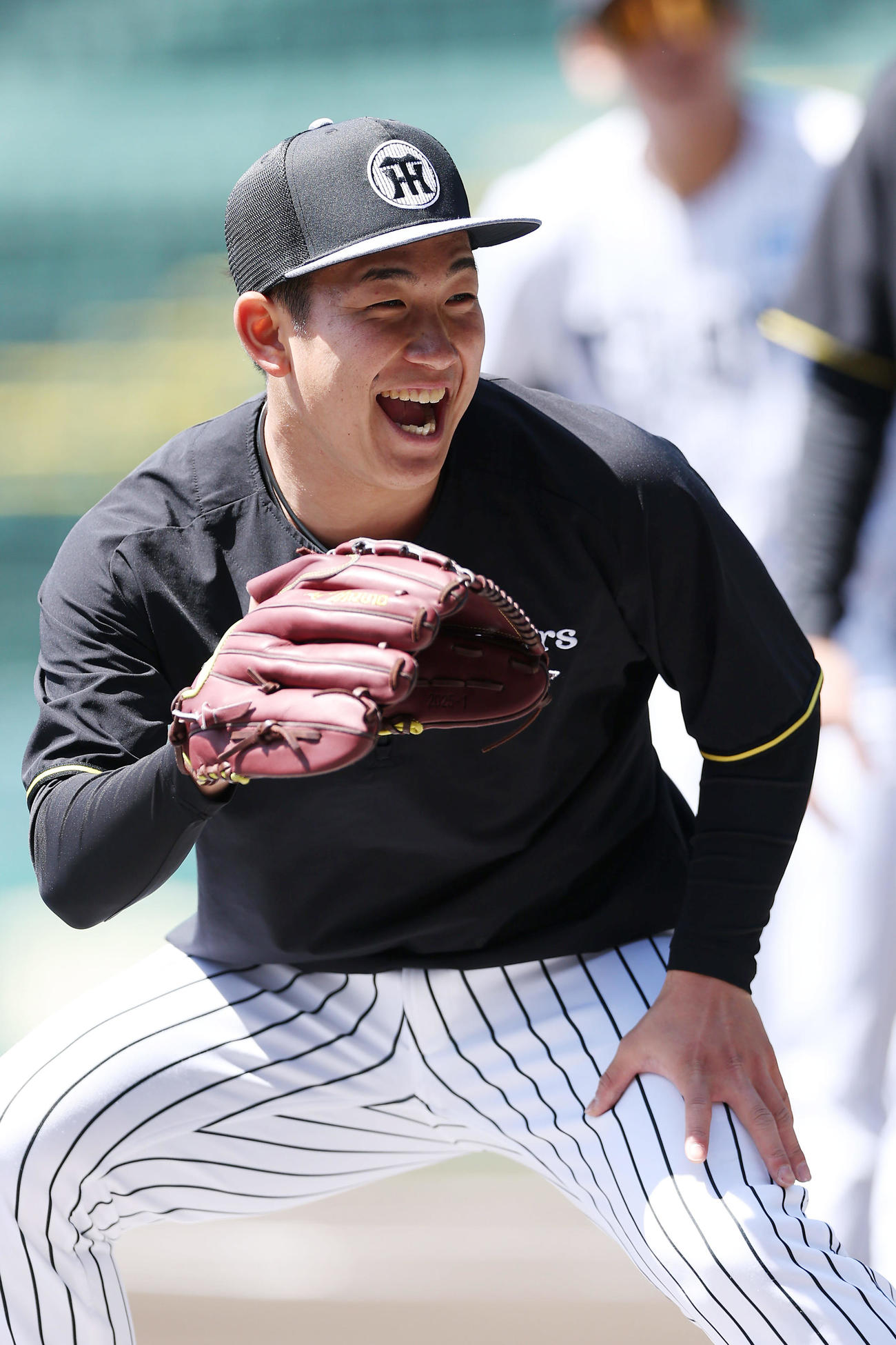 笑顔を見せながら投内連係を行う阪神伊原（撮影・前田充）