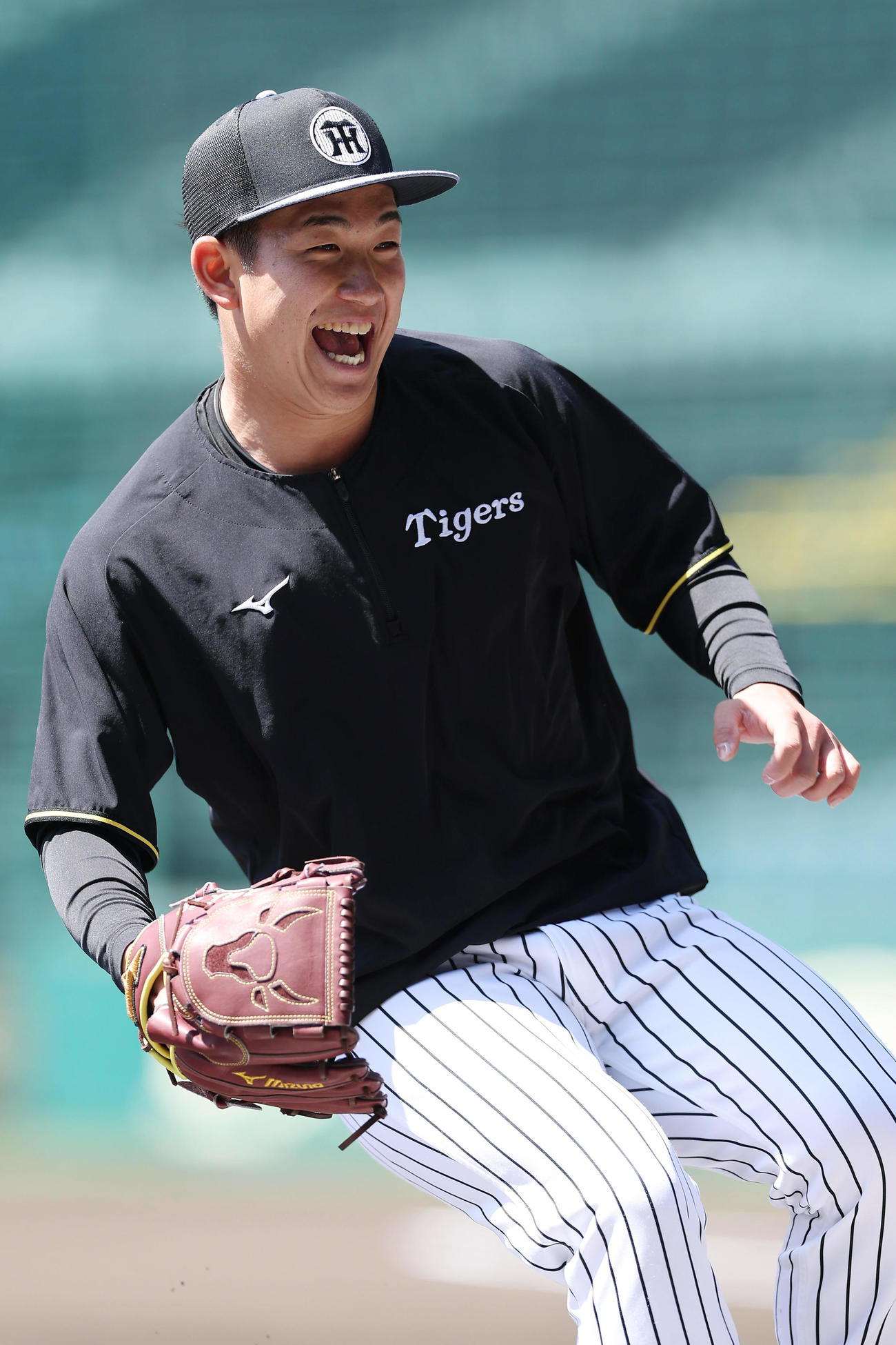 笑顔を見せながら投内連係を行う阪神伊原（撮影・前田充）