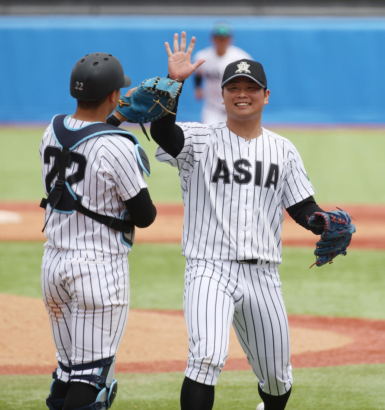 国学院大対亜大　6回途中から登板した亜大・井上（右）は4勝目を挙げ前嶋捕手ととハイタッチする（撮影・柴田隆二）