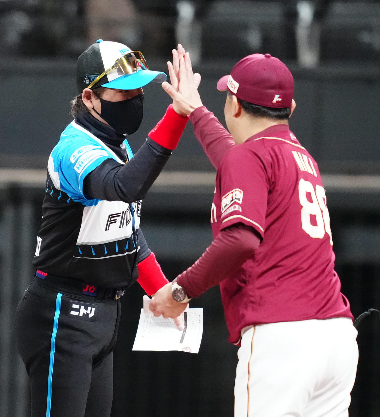 日本ハム対楽天　試合前、メンバー表の最終確認で楽天三木監督（右）とタッチを交わす日本ハム新庄監督（撮影・江口和貴）
