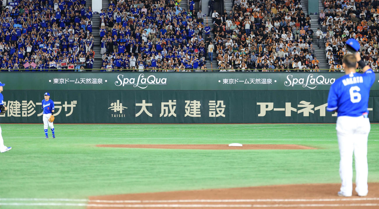 巨人対中日　5回裏巨人の攻撃前、「ハッピーバースデー」のボードを掲げる中日ファンにあいさつする中田（手前）（撮影・浅見桂子）