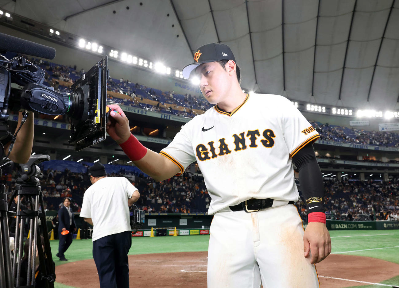 巨人対中日　ヒーローインタビュー後、TVカメラにサインする巨人岡本（撮影・浅見桂子）