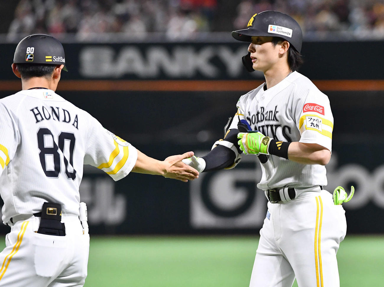 ソフトバンク対オリックス　4回裏ソフトバンク無死、二塁内野安打で出塁した周東（右）は本多コーチとタッチを交わす（撮影・岩下翔太）