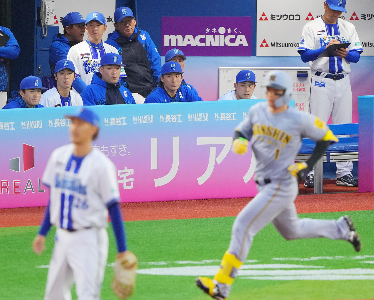 DeNA対阪神　1回表阪神1死三塁、森下（手前右）の適時打で先制を許しさえない表情の三浦監督（後方左から3人目）（撮影・垰建太）
