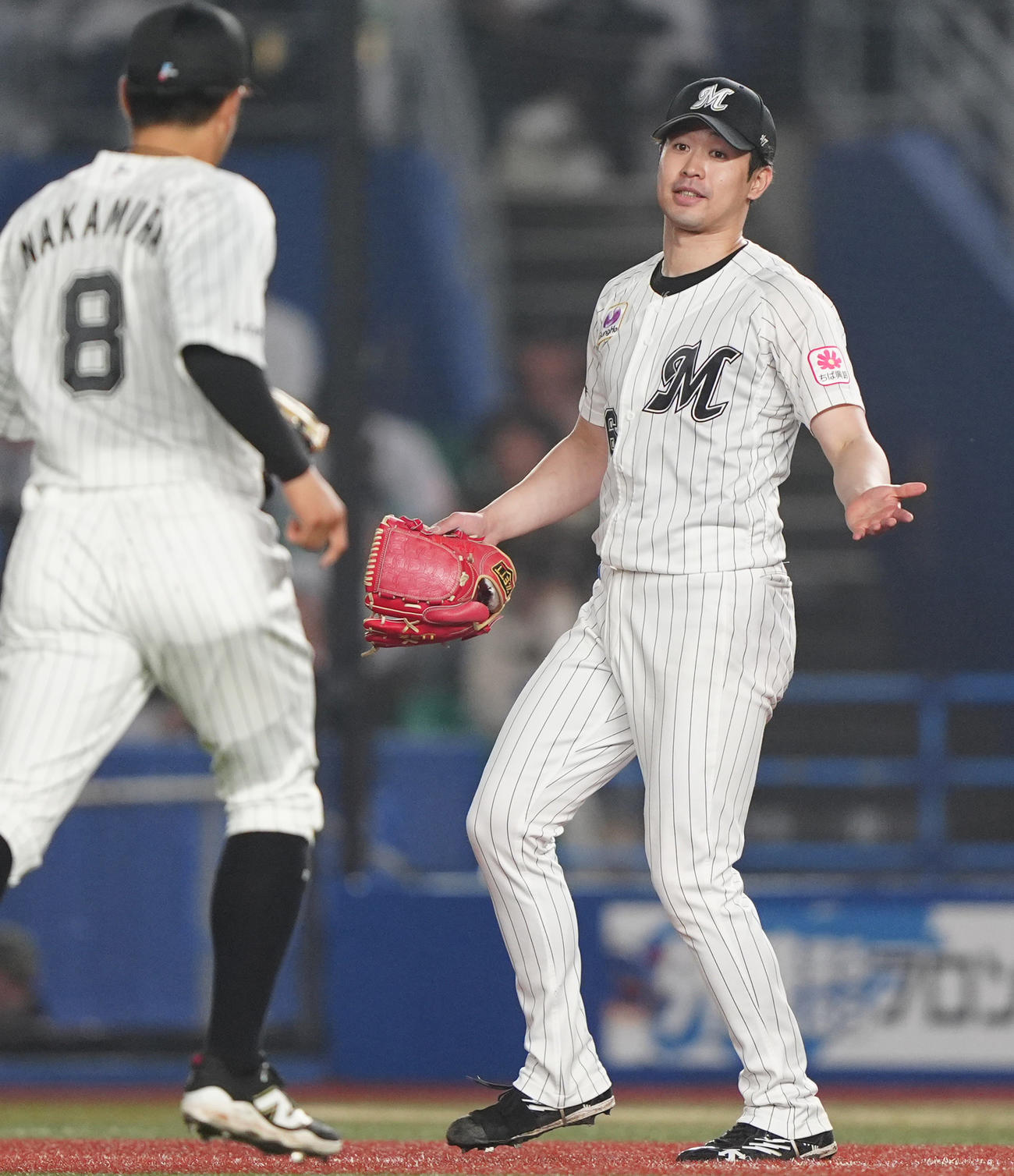 ロッテ対西武　5回表を終え中村奨（左）とタッチを交わす先発種市（撮影・清水貴仁）