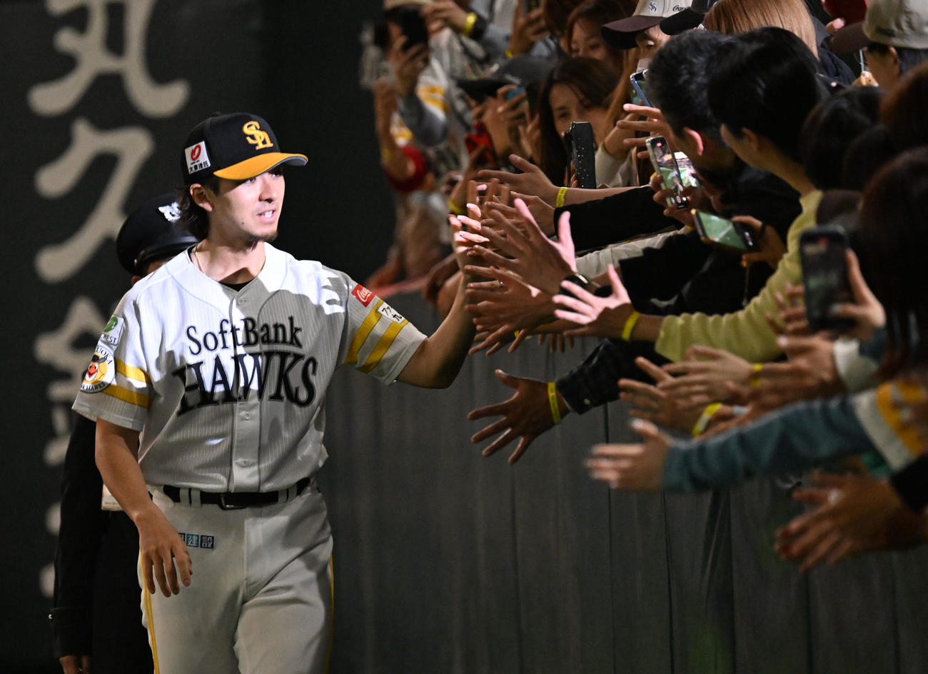 ソフトバンク対オリックス　ファンとタッチを交わす上沢（左）（撮影・林敢治）