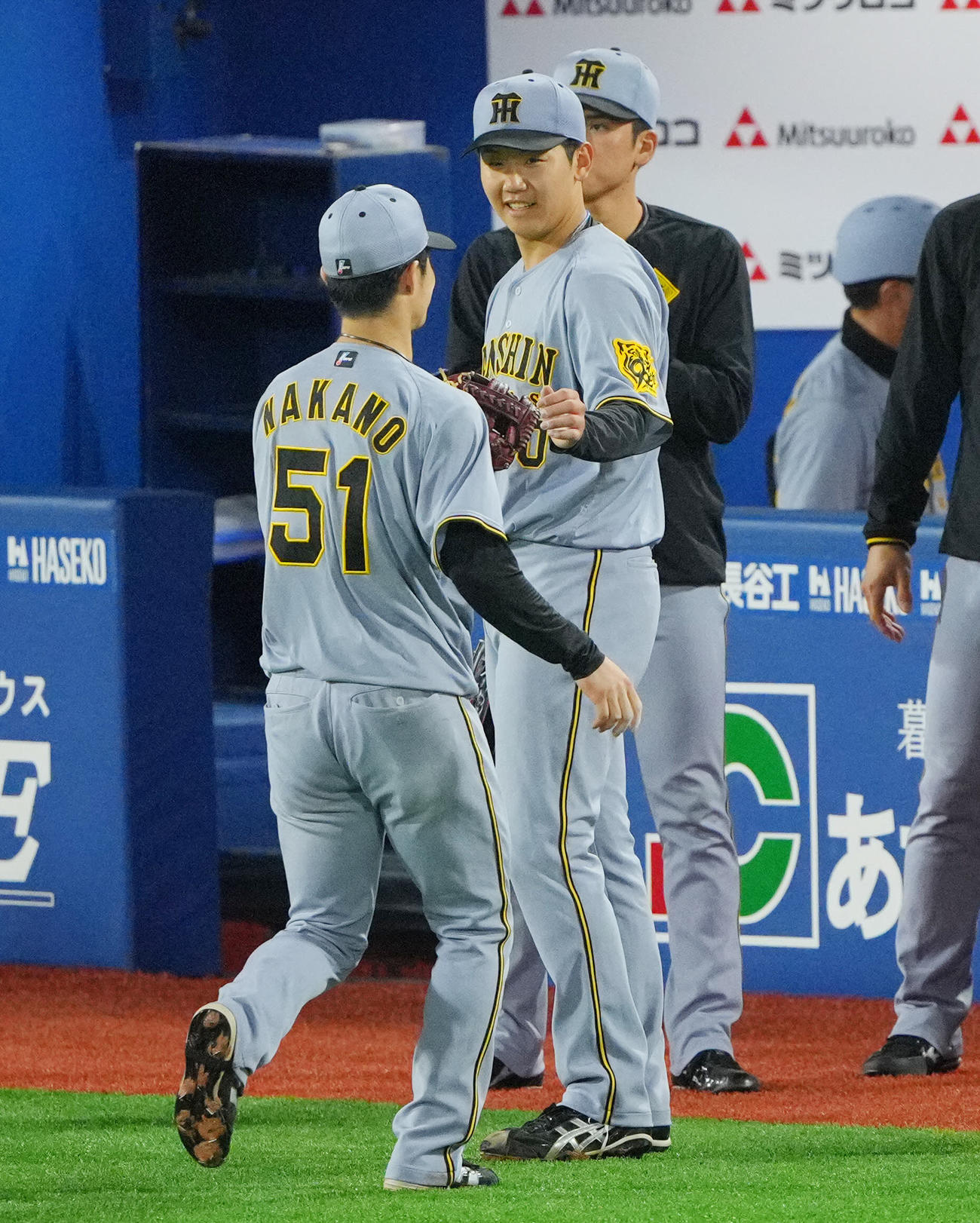 DeNA対阪神　5回裏DeNA2死一塁、代打度会を右飛に仕留め無失点の門別（右）は中野と笑顔でタッチを交わす（撮影・垰建太）