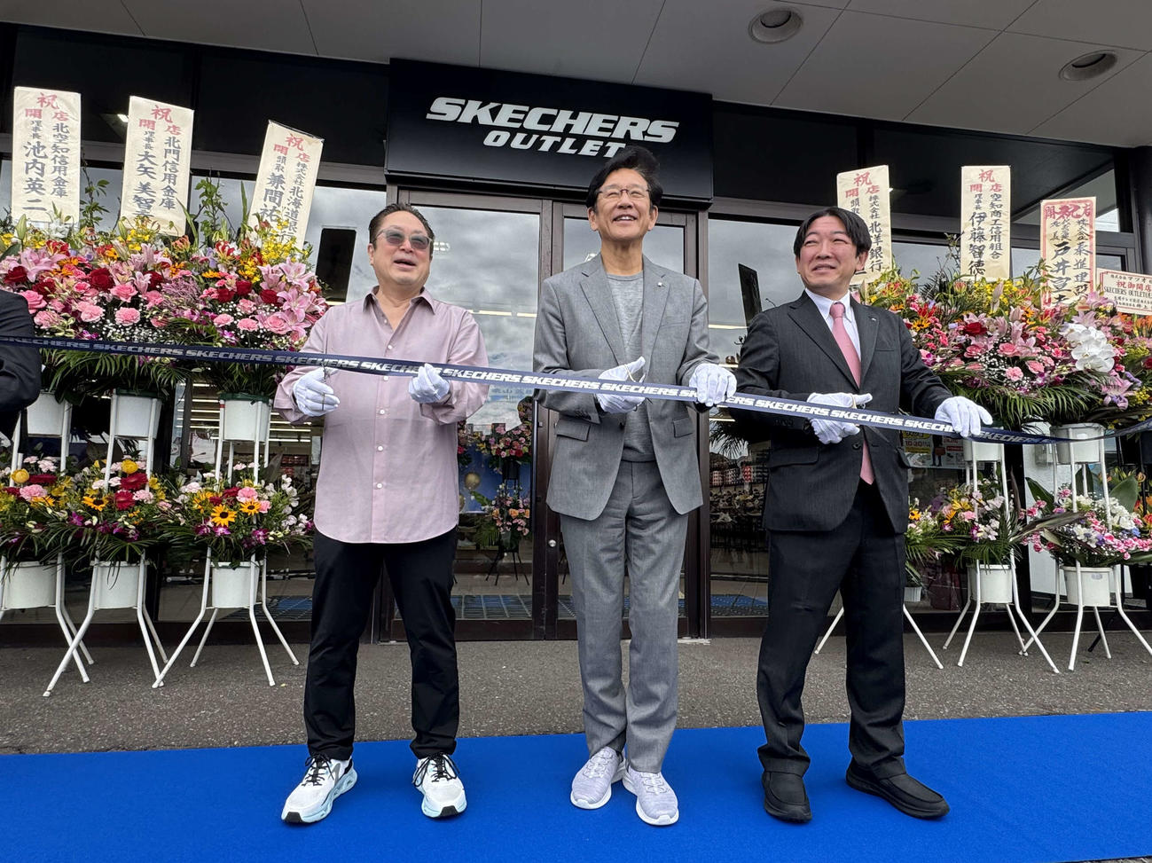 「スケッチャーズ　アウトレット札幌上野幌店」のオープニングセレモニーでテープカットを行う日本ハム栗山英樹CBO（左はスケッチャーズジャパン合同会社のデイビッドK・トダ日本法人代表、右はストアオーナーの株式会社マツオの松尾吉洋代表取締役）（撮影・木下大輔）