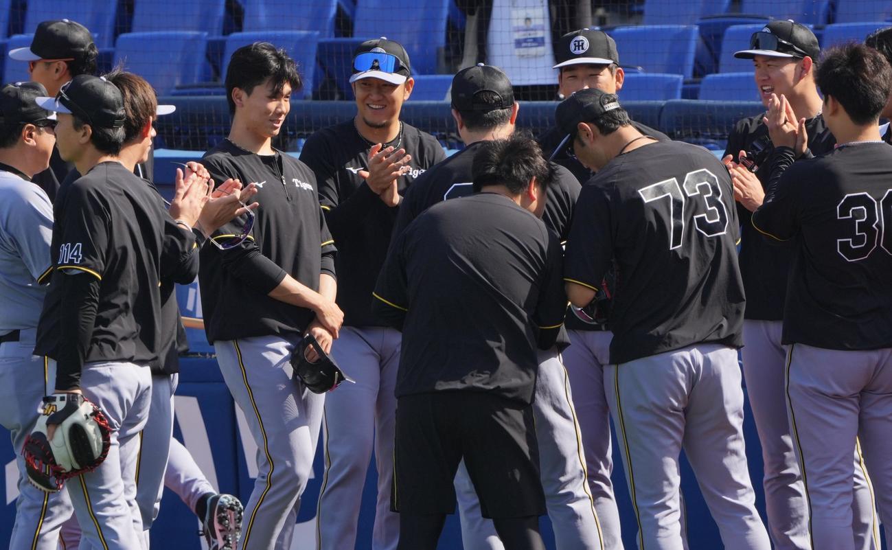 DeNA対阪神　試合前、投手陣に笑顔であいさつする阪神湯浅（左）（撮影・垰建太）