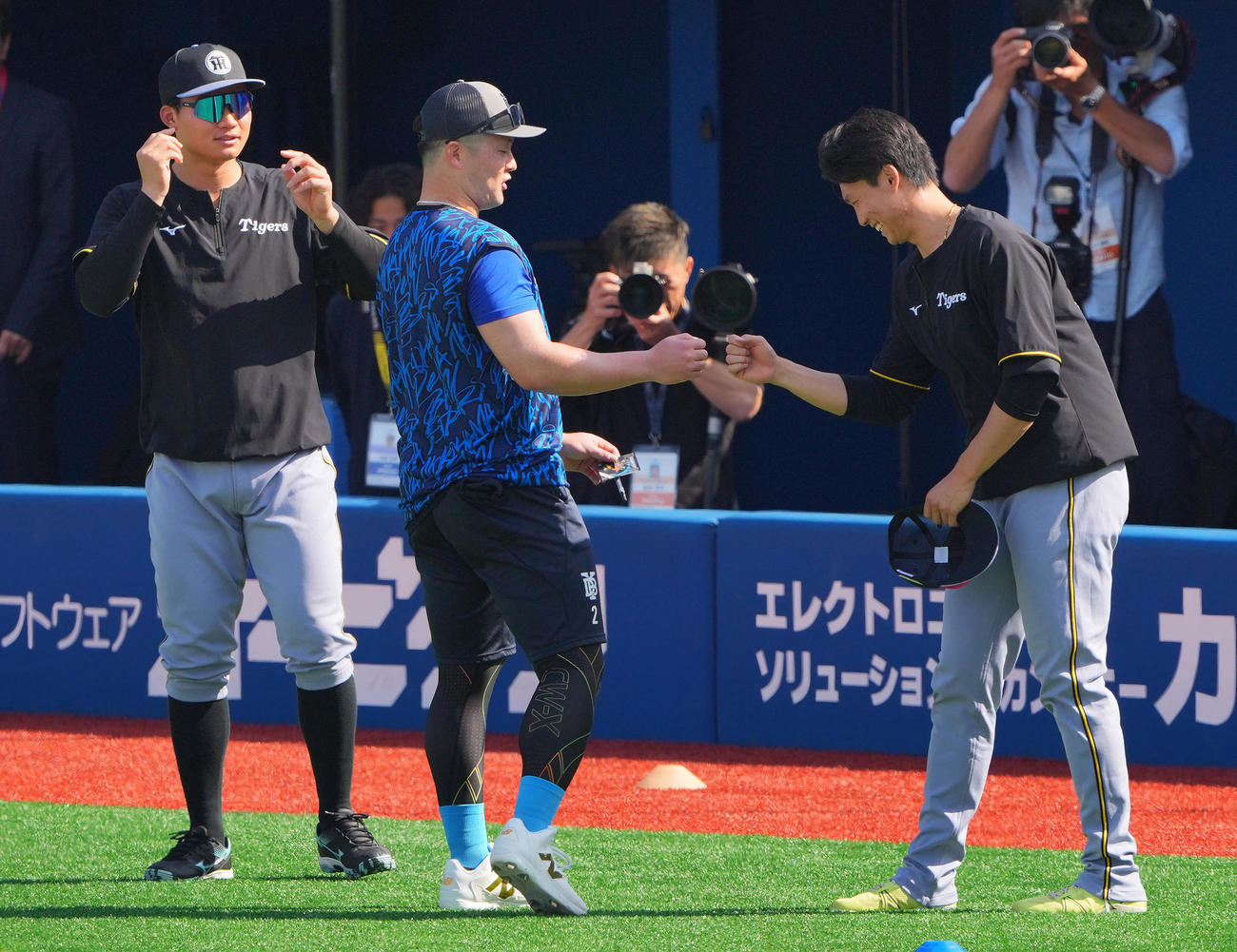 DeNA対阪神　試合前、DeNA牧（中央）とグータッチを交わす阪神湯浅（右）（撮影・垰建太）