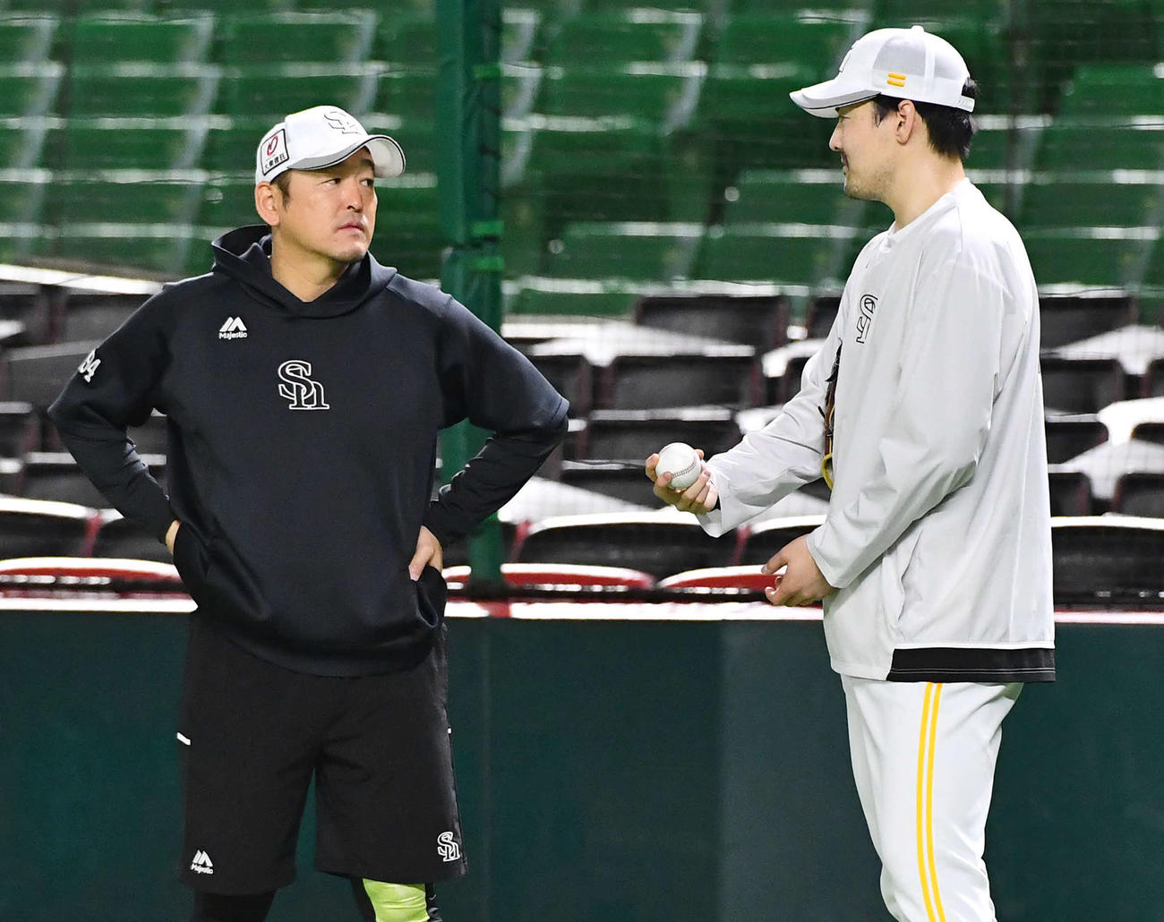 キャッチボールを終えた有原（右）は倉野コーチと話し合う（撮影・岩下翔太）