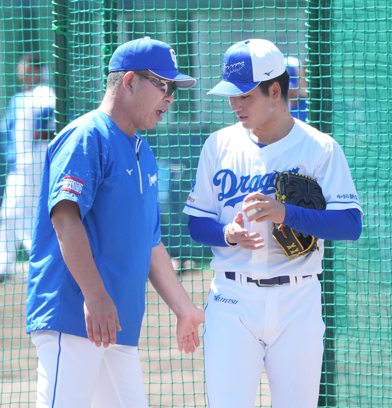 ブルペンで投球練習をする金丸（右）に声をかける井上監督（撮影・森本幸一）