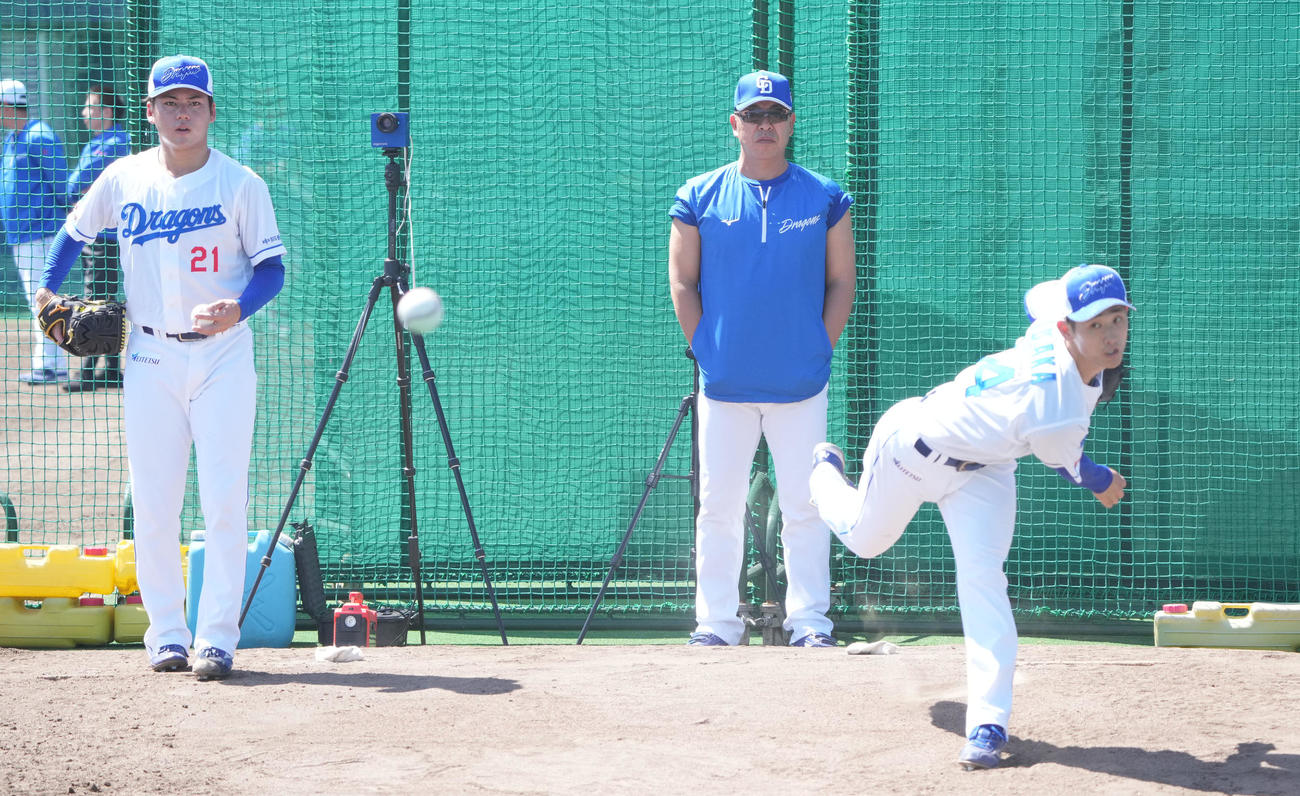 井上監督（中央）はブルペンで投球練習をする金丸と草加を見つめる（撮影・森本幸一）