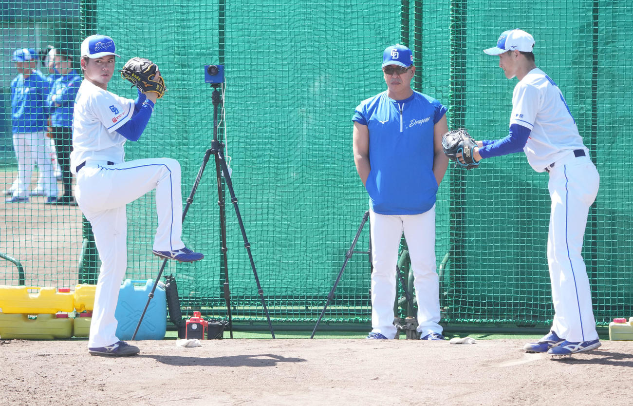 井上監督（中央）はブルペンで投球練習をする金丸と草加を見つめる（撮影・森本幸一）