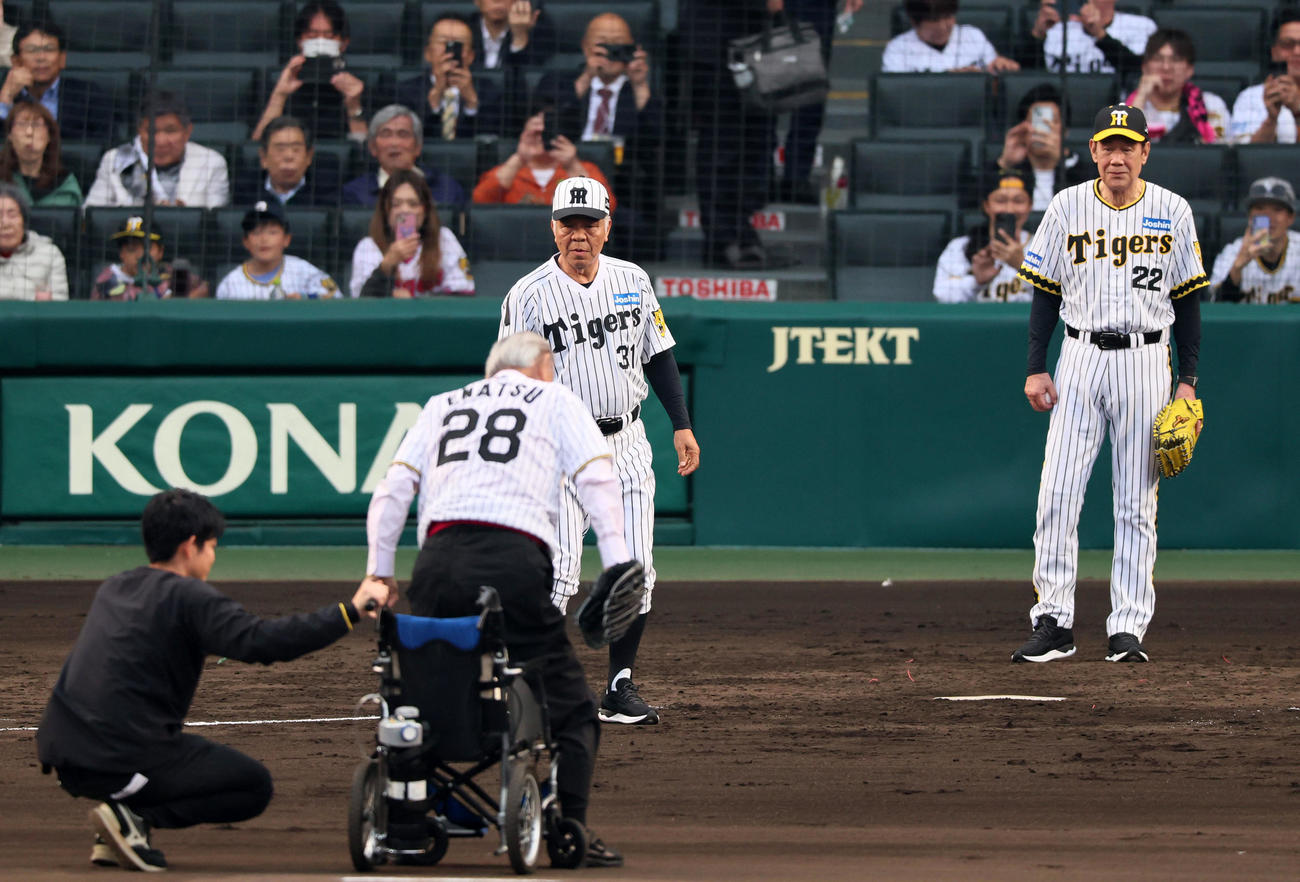 阪神対巨人阪神球団創設90周年のレジェンズデー企画でファーストピッチセレモニーを行うため車椅子から立ち上がる江夏氏。中央はびっくりしてマウンドへ向かおうとする掛布氏。右は田淵氏（撮影・加藤哉）
