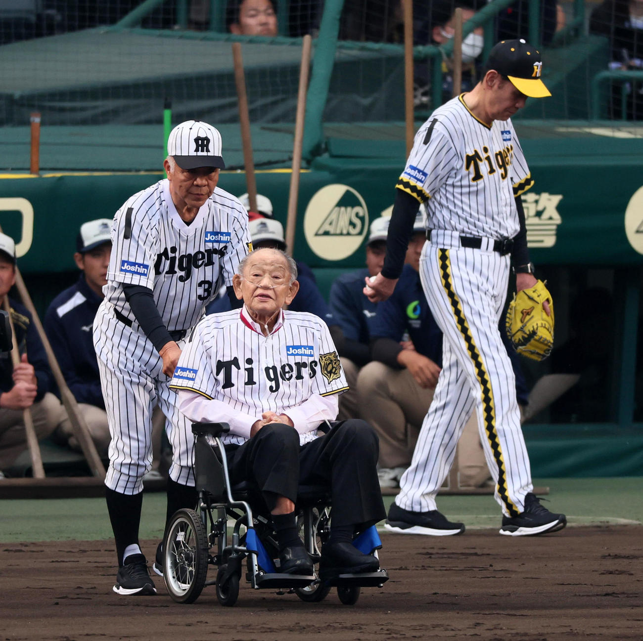 阪神対巨人　阪神球団創設90周年のレジェンズデー企画でファーストピッチセレモニーを行うため江夏氏の車椅子を押す掛布氏。右は田淵氏（撮影・加藤哉）