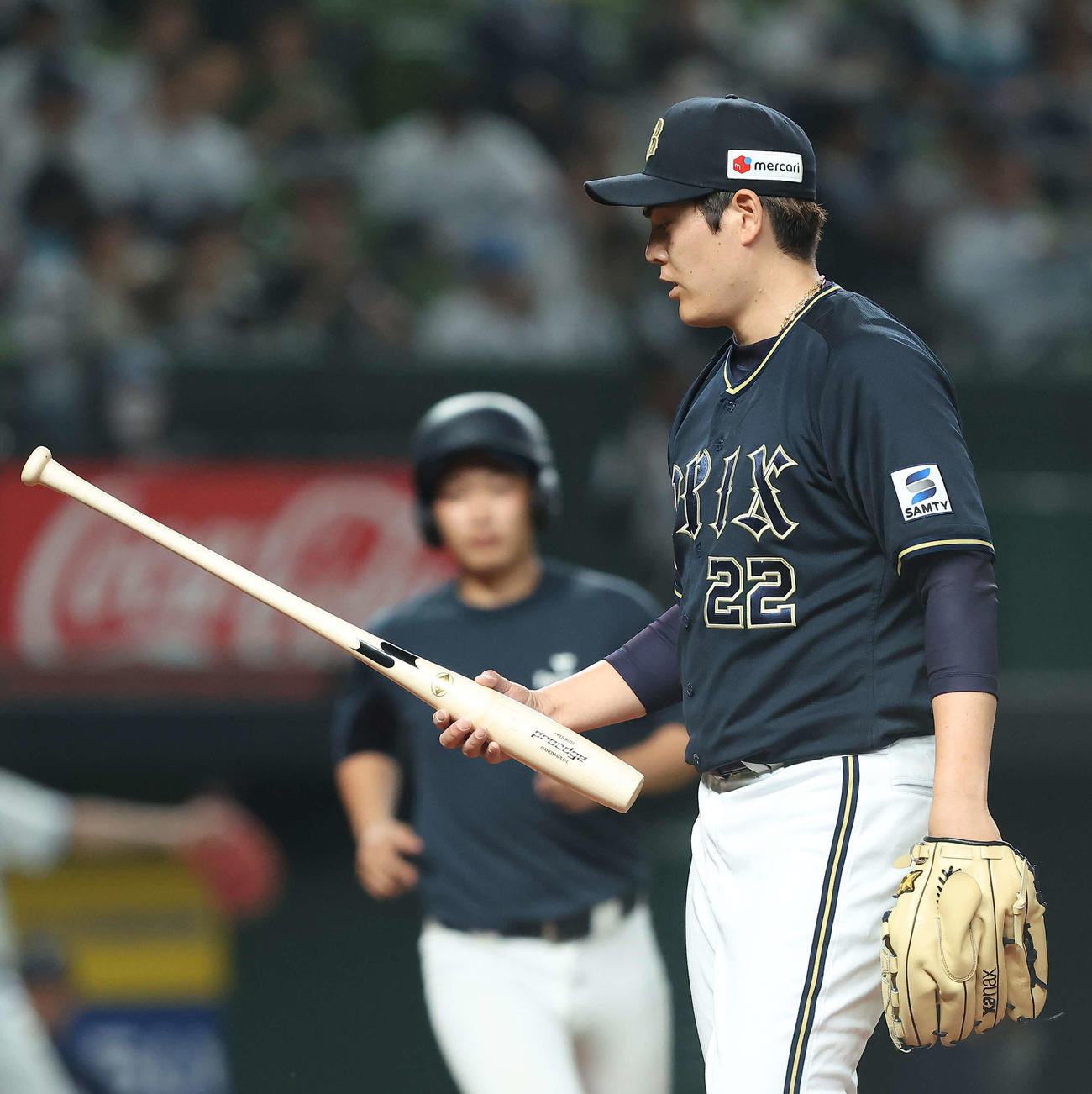 西武対オリックス　3回裏を終え、中飛に抑えた中村剛のバットを手にする九里（撮影・河田真司）