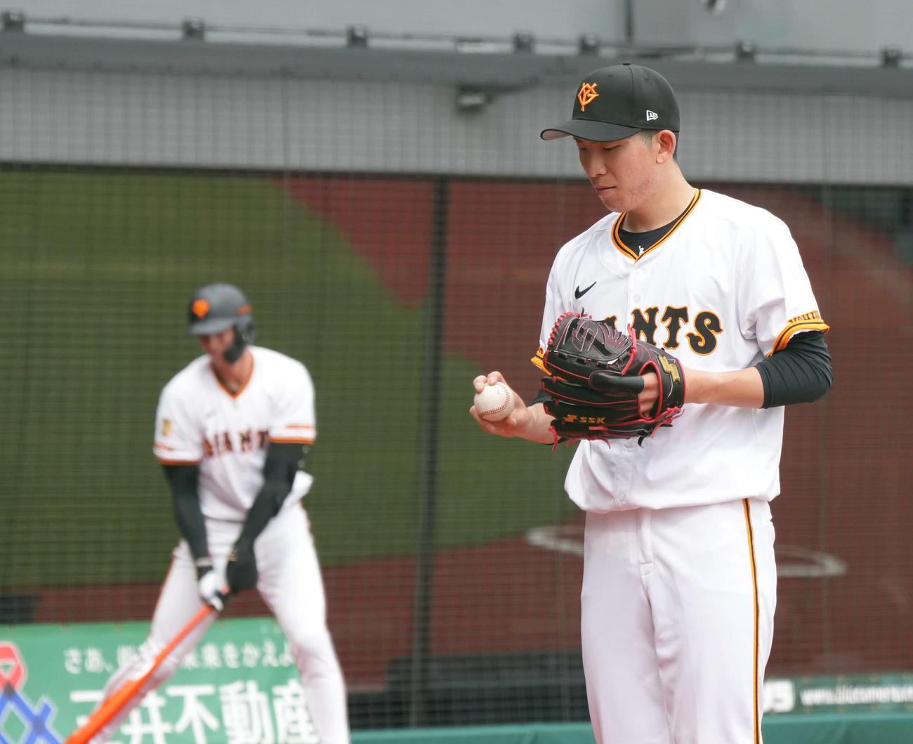 イースタン公式戦　巨人対日本ハム　巨人2番手で登板した戸郷はベンチ前でのキャッチボールでボールの握りを見つめる（撮影・小沢裕）