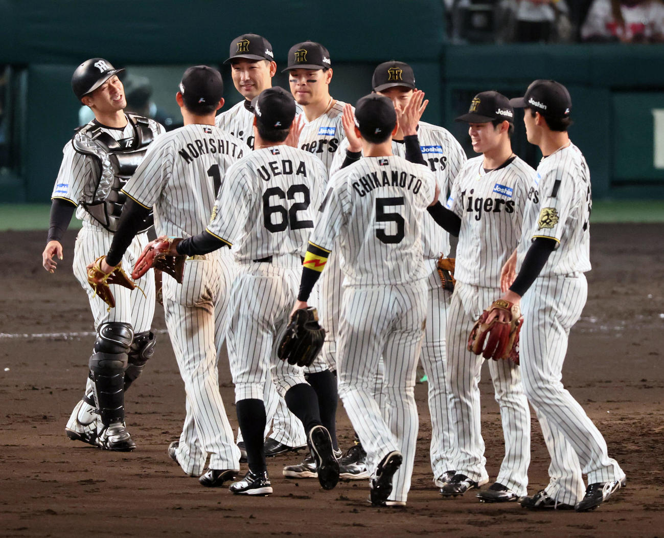 阪神対巨人　9回表巨人2死一塁、キャベッジを三振に仕留めナインとマウンドでタッチする岩崎（撮影・加藤哉）