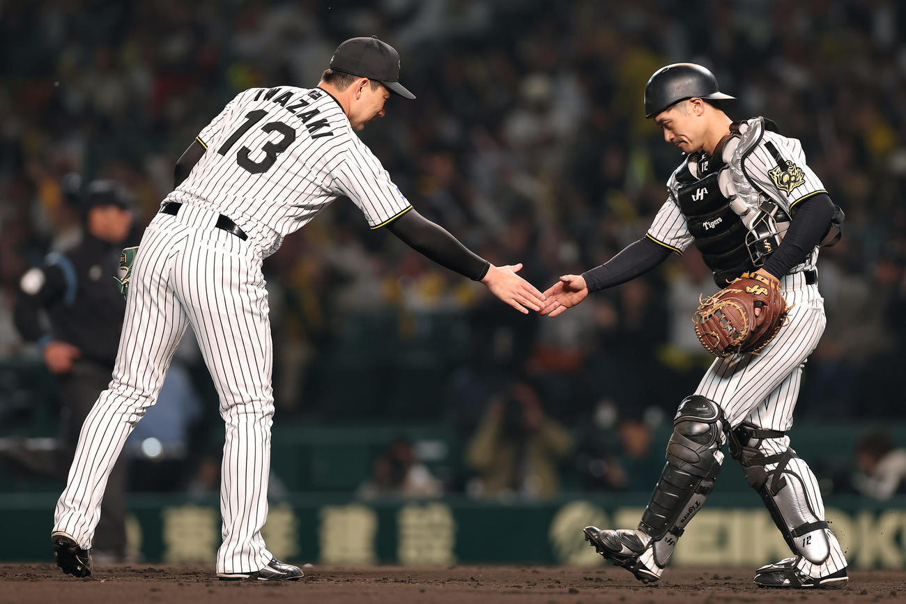 阪神対巨人　巨人に勝利し、握手を交わす阪神岩崎（左）と坂本（撮影・前田充）