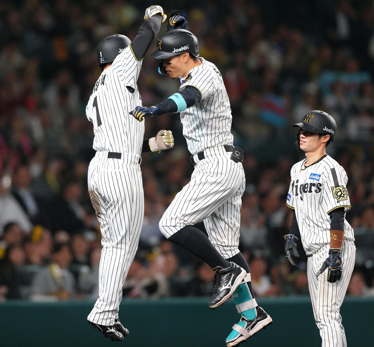 阪神対巨人　3回裏阪神1死一、二塁、佐藤輝（中央）は中越え3点本塁打を放ち森下とタッチをかわす。右は中野（撮影・上山淳一）