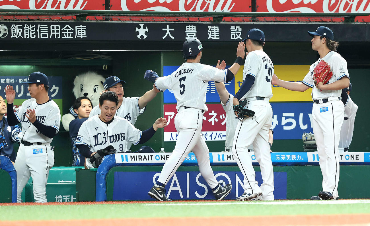 西武対オリックス　6回裏西武2死満塁、滝沢の四球で押し出し生還する外崎（中央）を迎える今井（右）らチームメート（撮影・河田真司）