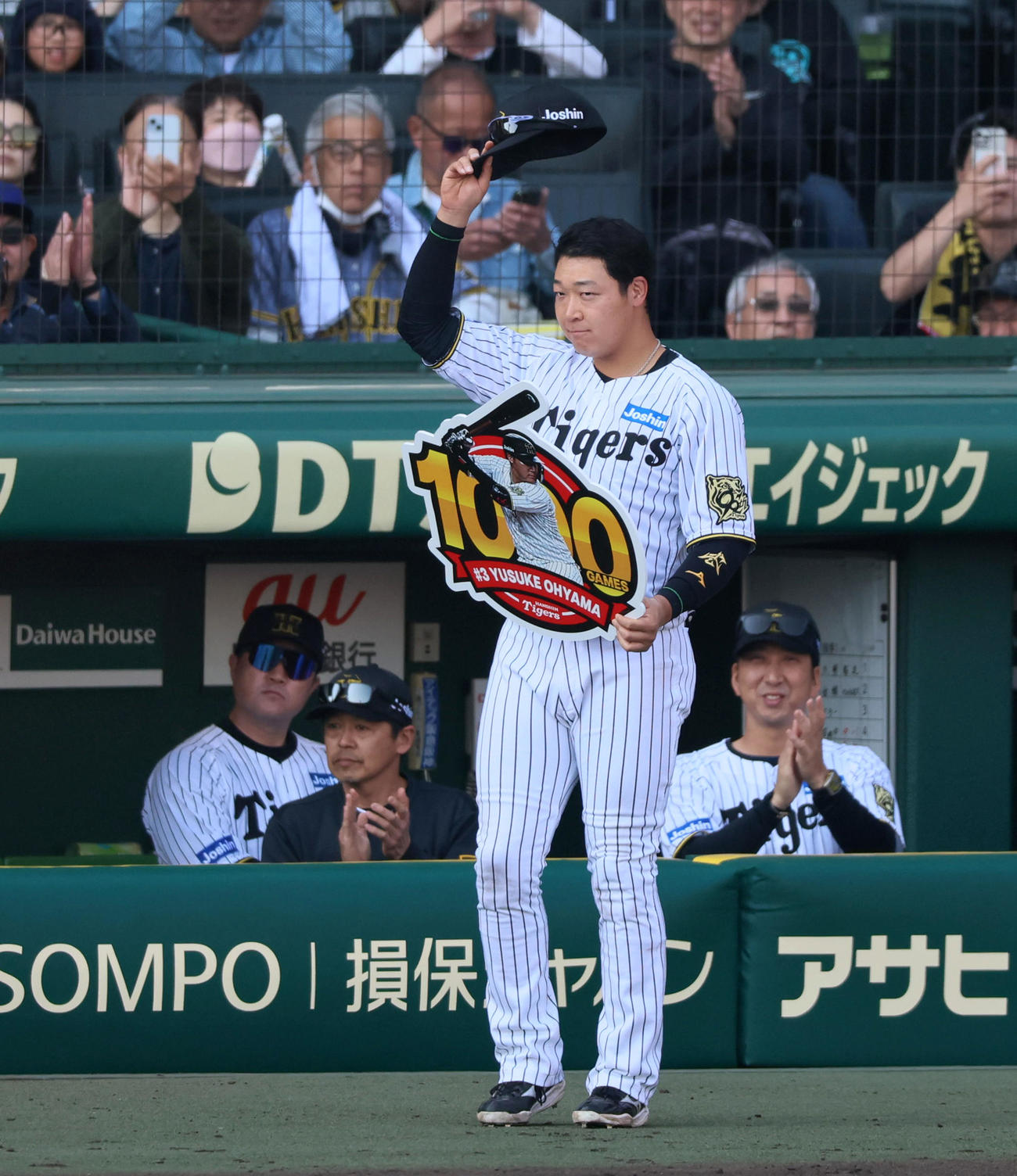 阪神対巨人　この試合で1000試合出場達成の大山は記念のパネルを手にスタンドへあいさつする（撮影・加藤哉）