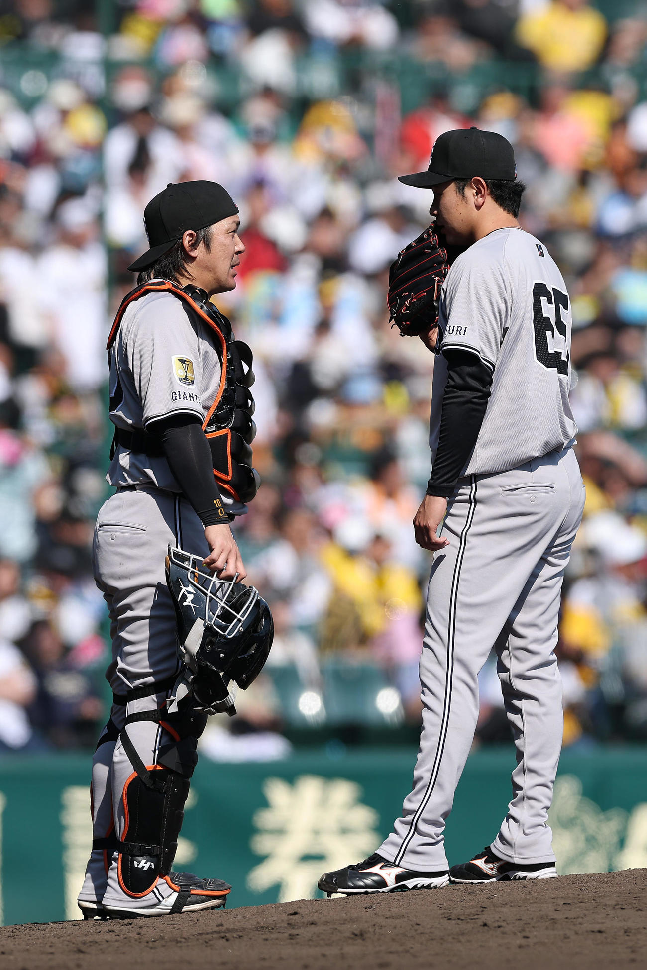 阪神対巨人　4回裏無死一塁、打者佐藤輝を迎え、マウンドで言葉を交わす甲斐（左）と石川（撮影・前田充）