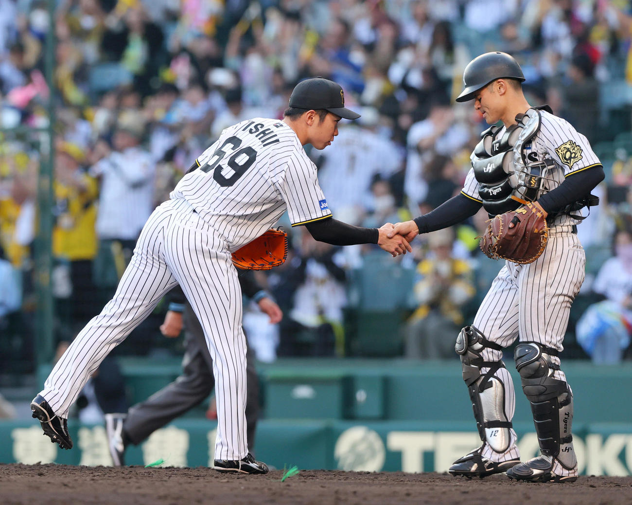 阪神対巨人　巨人に勝利し、試合を締めた阪神石井（左）は捕手坂本と握手をかわす（撮影・上山淳一）